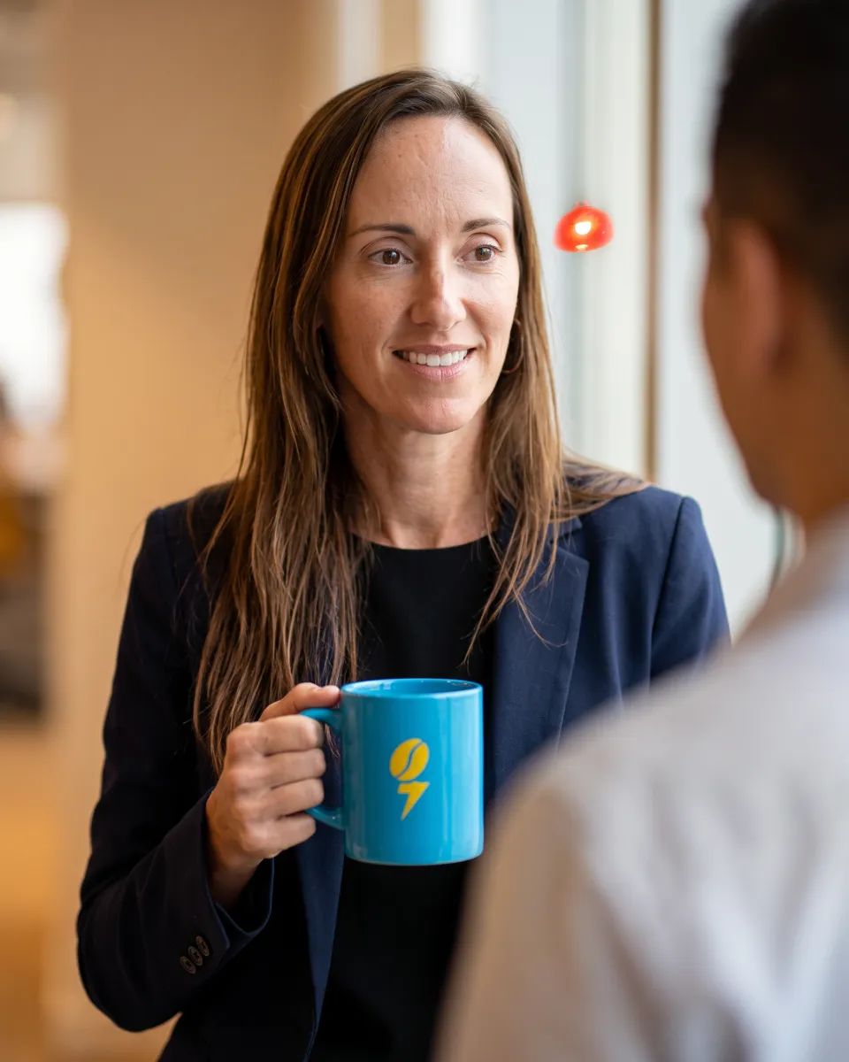 Krista Talcott holding a blue Everygrind mug in the office